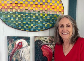 a woman standing in front of some paintings