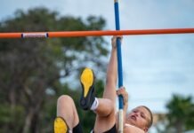 a young boy is doing a high bar exercise