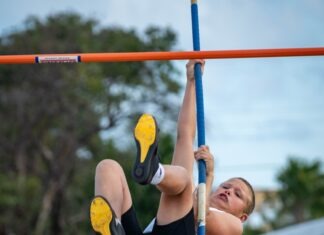 a young boy is doing a high bar exercise