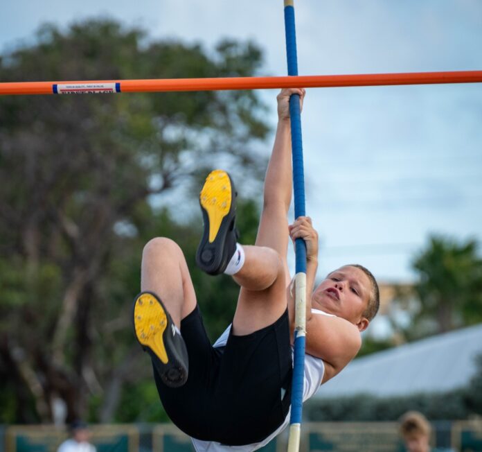 a young boy is doing a high bar exercise