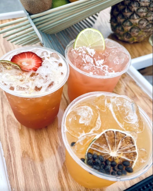 three drinks are sitting on a wooden table