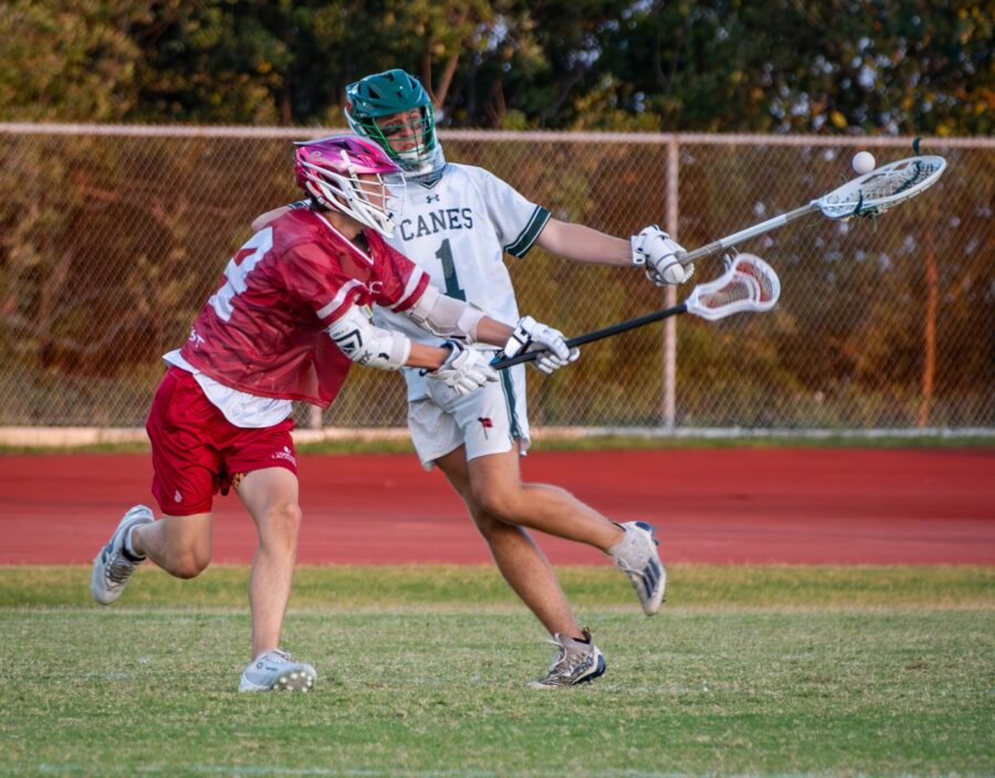 a couple of young men playing a game of lacrosse