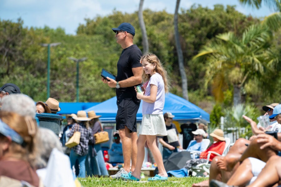 a man standing next to a little girl on top of a field