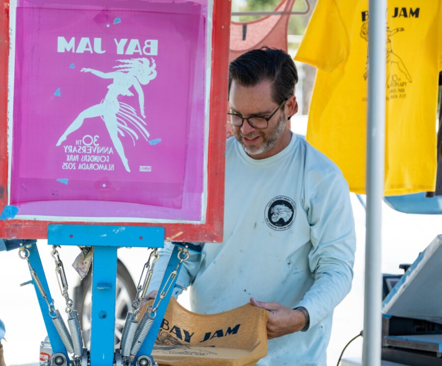 a man standing next to a table with a sign on it