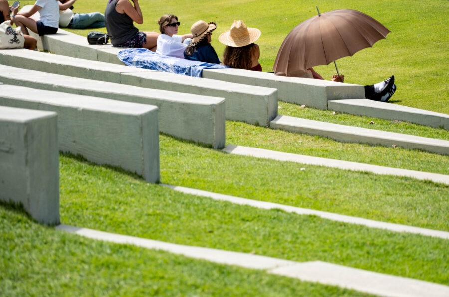 a group of people sitting on top of cement benches