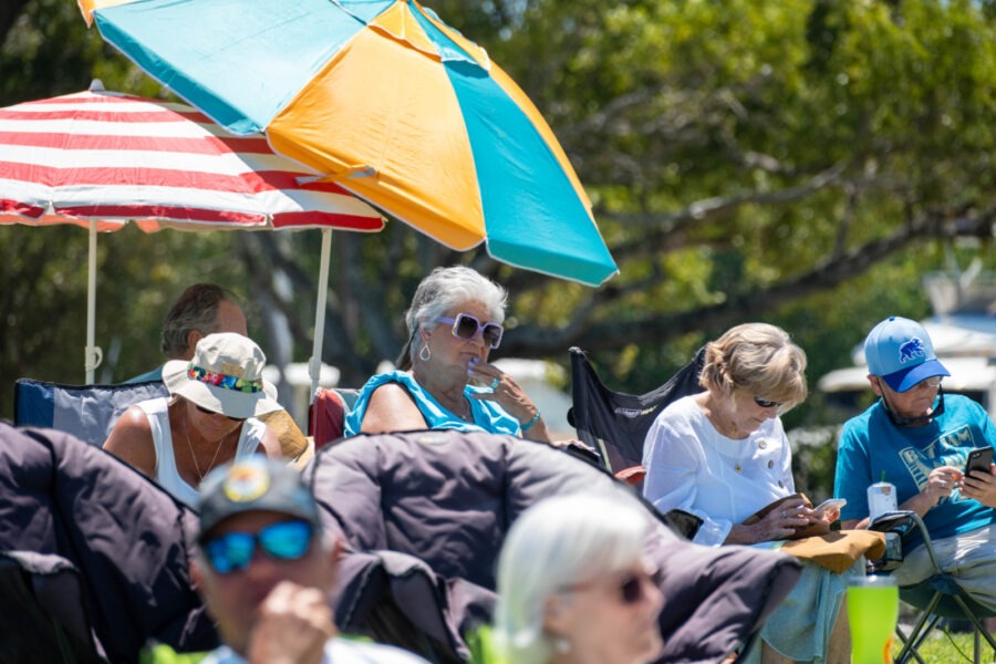 a group of people sitting under umbrellas in a park