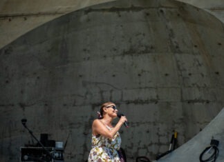 a woman in a dress sings into a microphone
