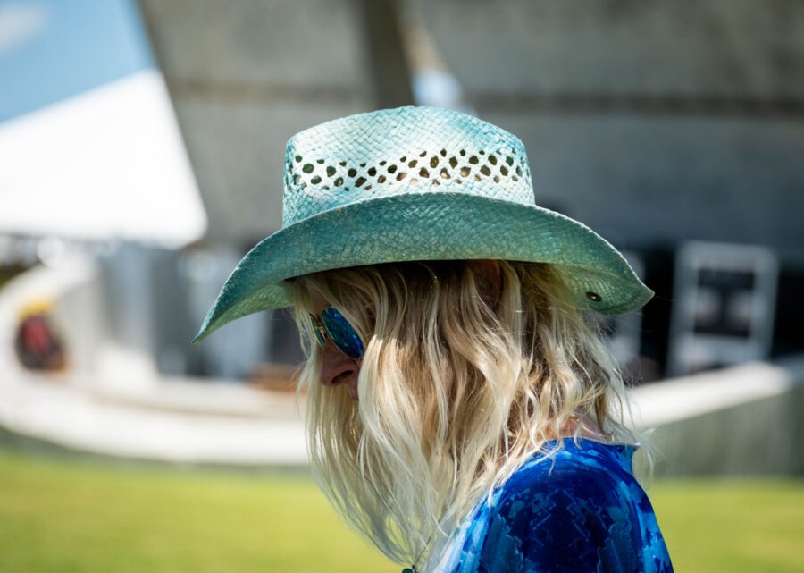 a woman wearing a blue shirt and a green hat
