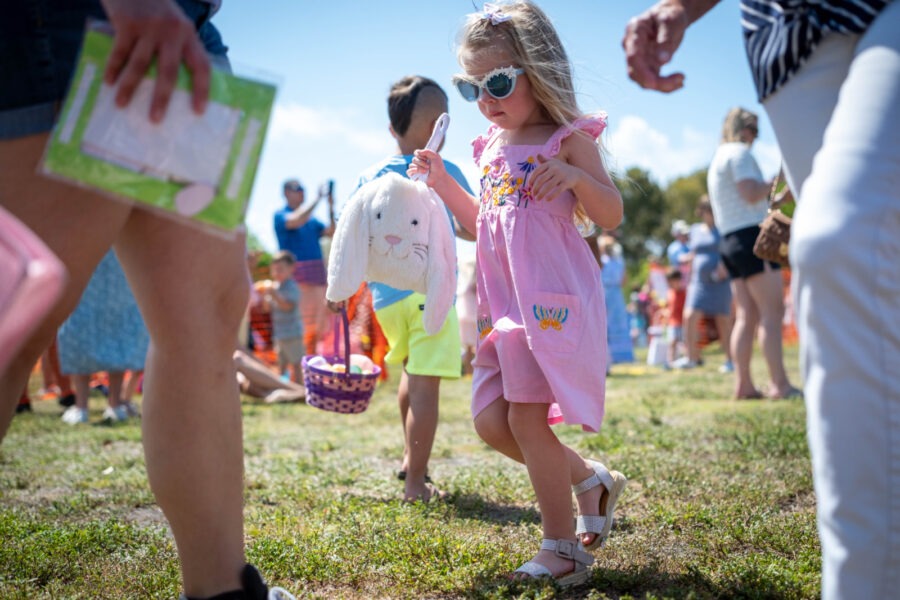 a little girl in a pink dress and sunglasses