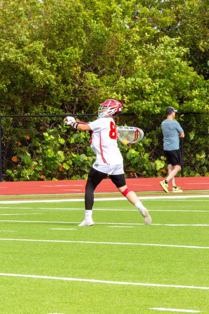 a person on a field with a lacrosse ball