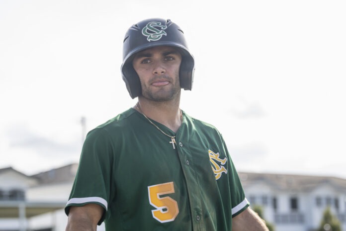 NikonD850 a man in a baseball uniform holding a bat