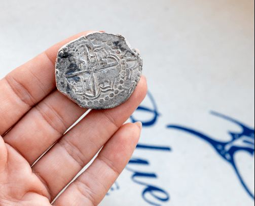 Blue Marlin coin a person holding a coin in their hand