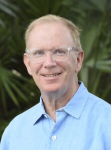 a man wearing glasses and a blue shirt