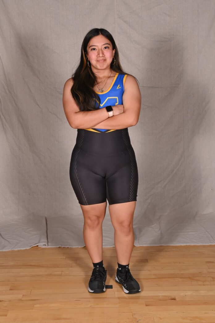 a woman standing in a studio with her arms crossed