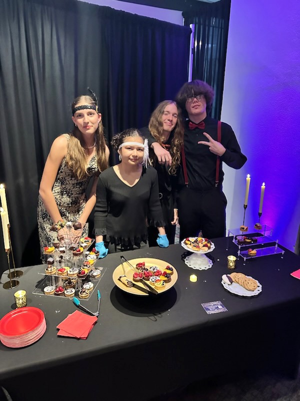a group of people standing around a table