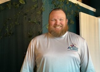 a man standing in front of a green wall