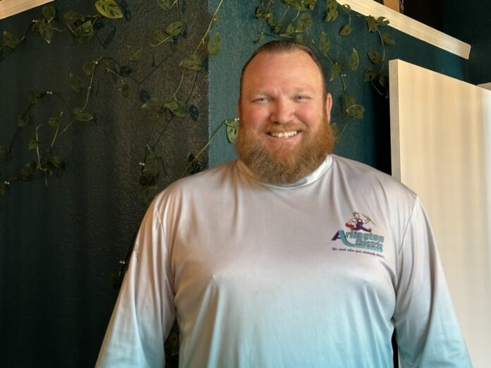 a man standing in front of a green wall