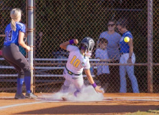 a softball player sliding into home plate during a game