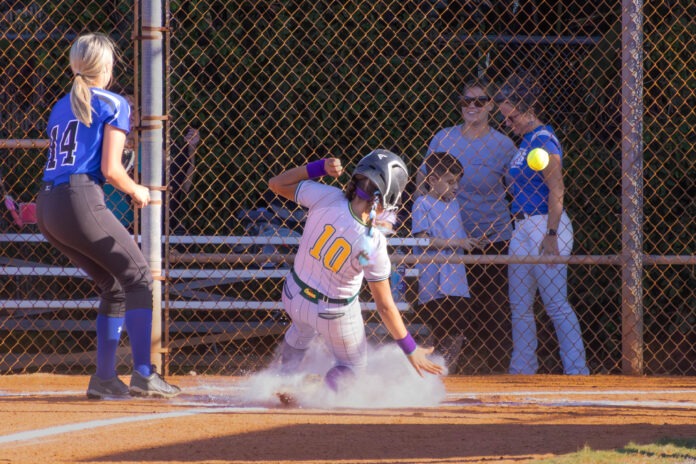 Coral Shores 2 a softball player sliding into home plate during a game