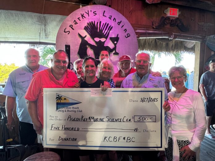 DONATION a group of people standing around a giant check