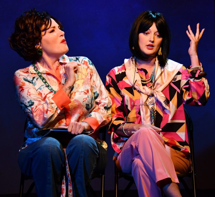a couple of women sitting next to each other on a stage