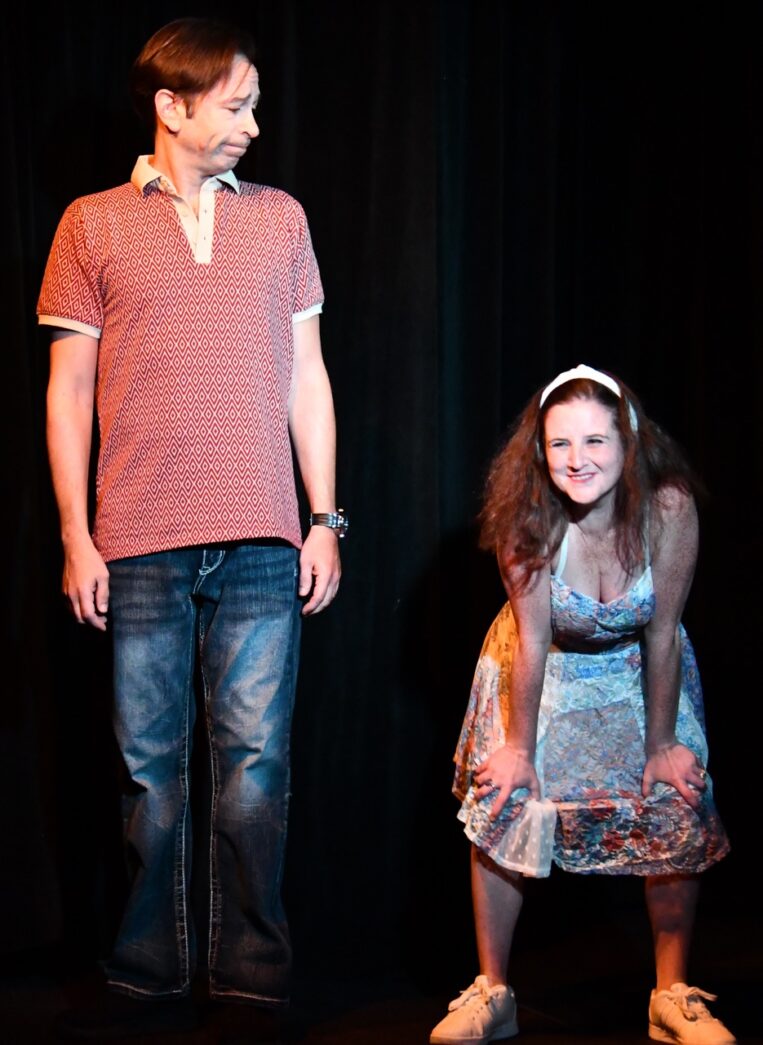 a man standing next to a little girl on a stage