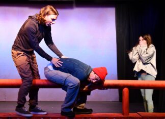a man is being assisted by a woman on a stage