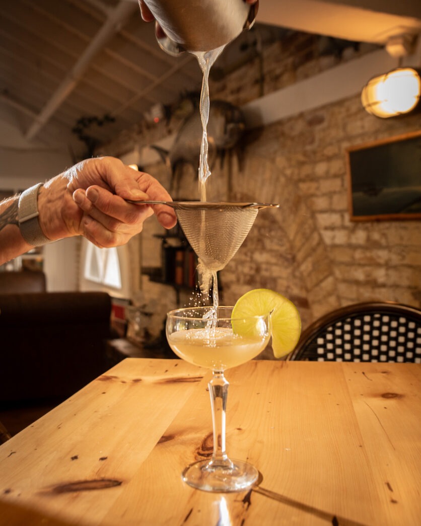 a person pouring a drink into a glass