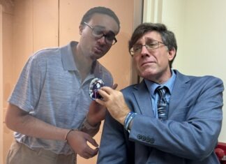 two men standing next to each other in front of a mirror
