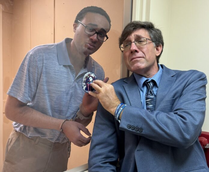 Daniel and Ari two men standing next to each other in front of a mirror