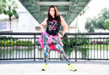 a woman is posing for a picture in front of a bridge