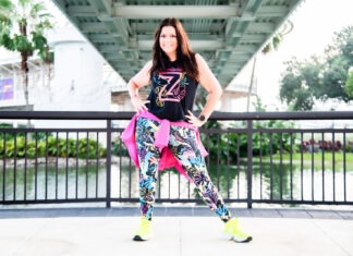 a woman is posing for a picture in front of a bridge