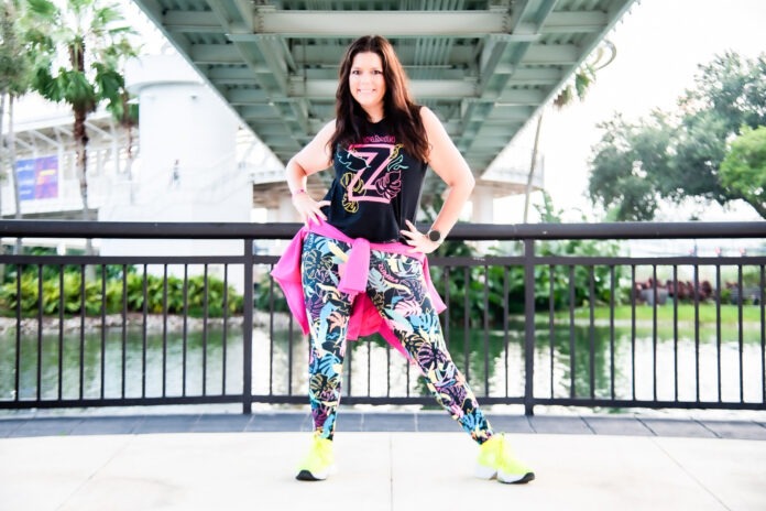 a woman is posing for a picture in front of a bridge