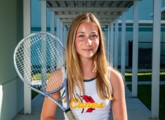 a young woman holding a tennis racquet on a tennis court