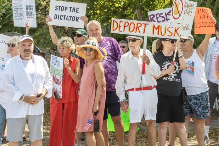 a group of people holding signs in front of a crowd