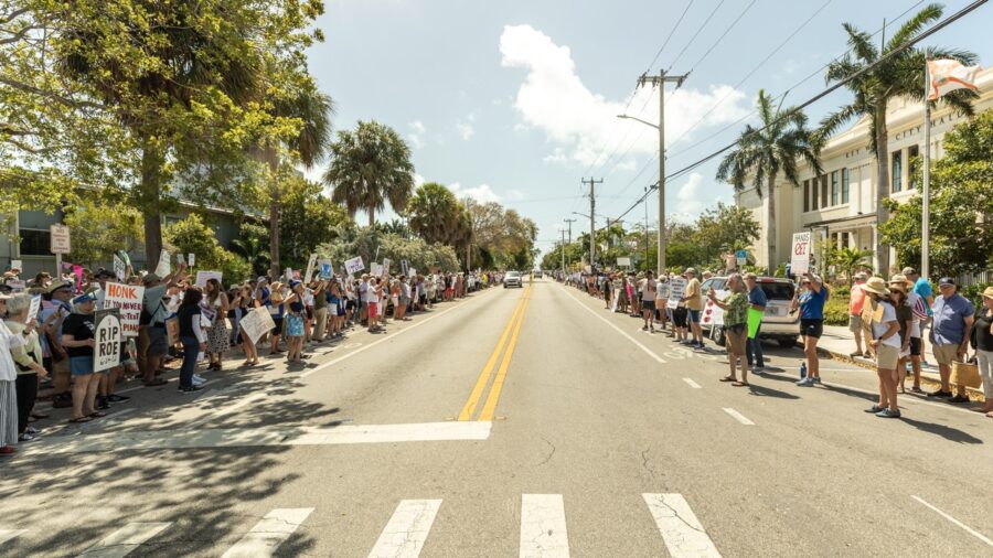 a group of people standing on the side of a road