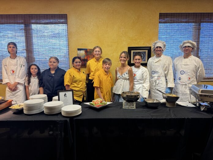 a group of people standing in front of a table