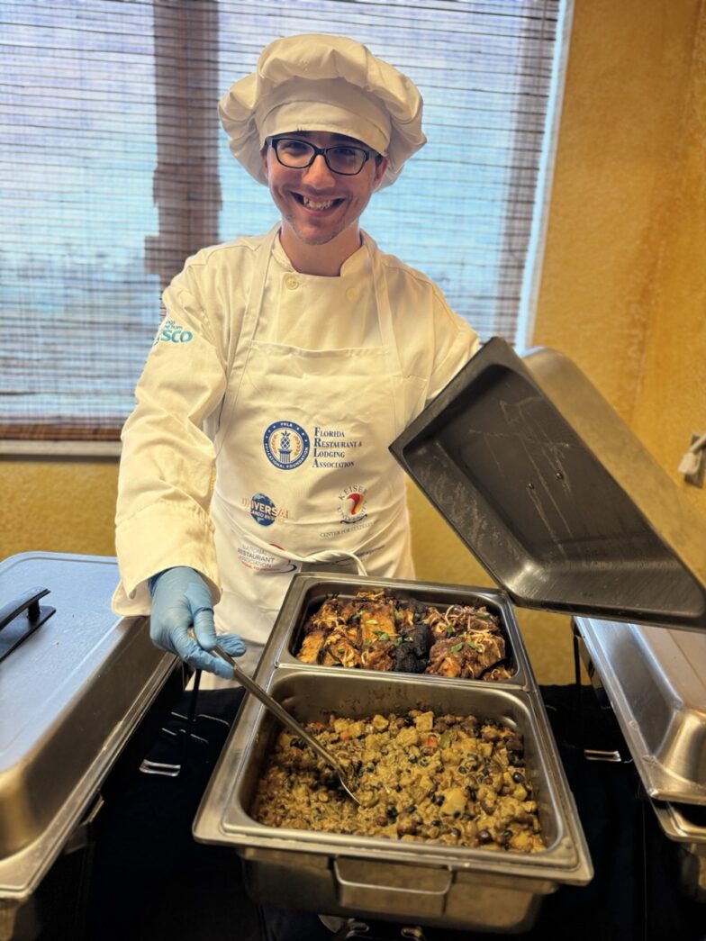 a woman in a chef's outfit holding a tray of food