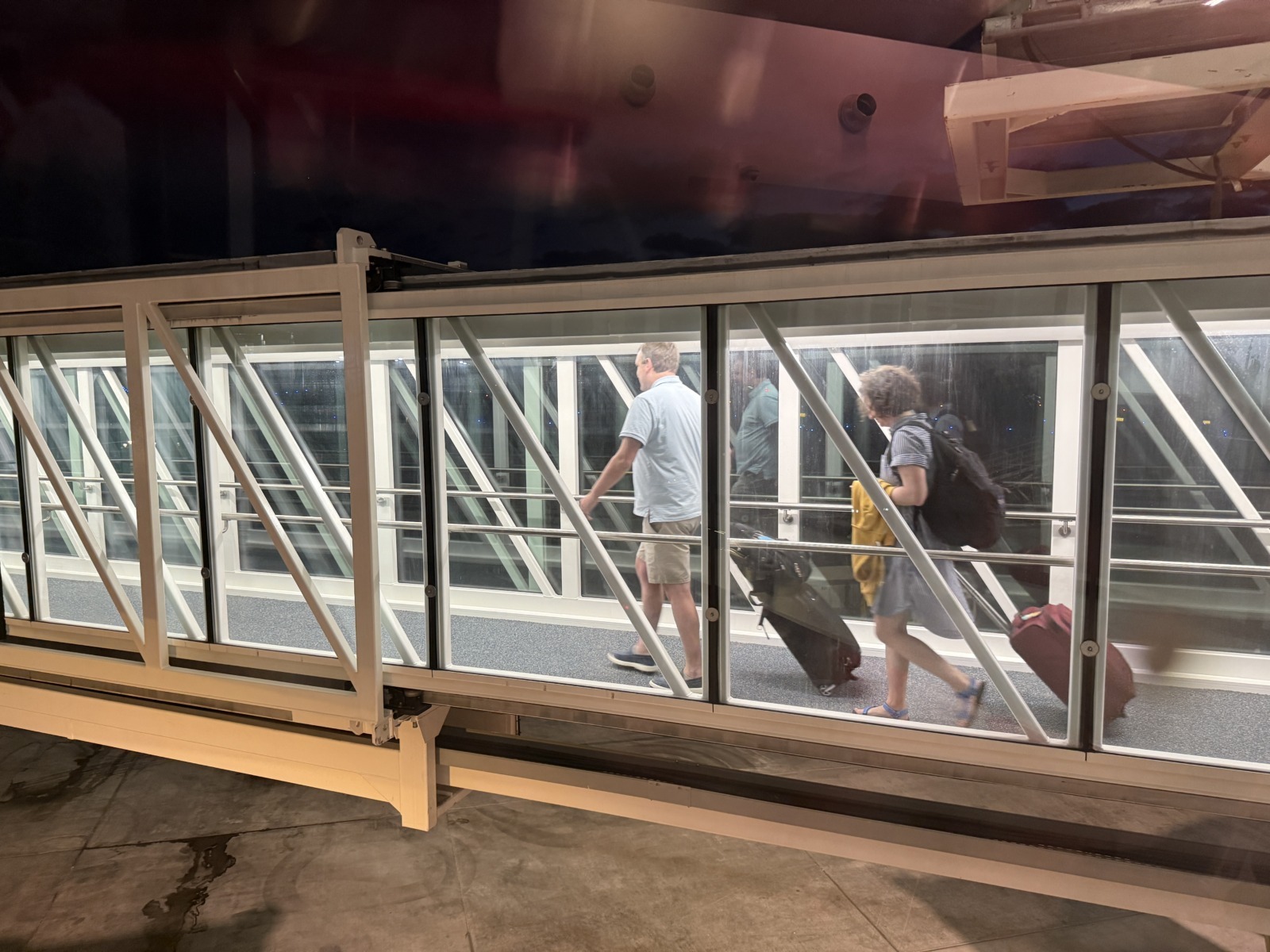 a group of people walking across a bridge with luggage