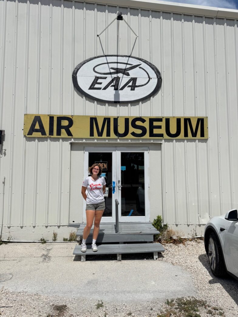 a woman standing in front of an air museum