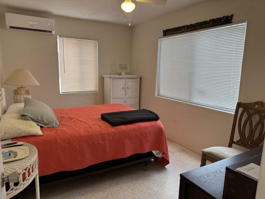 a bed room with a neatly made bed and a chair