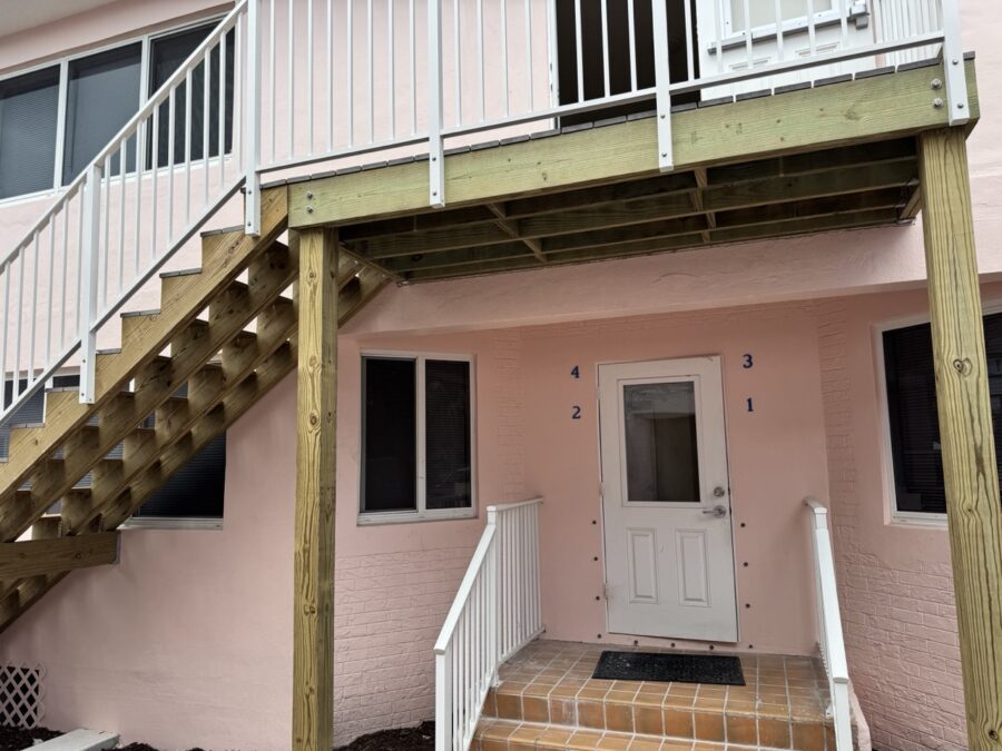 a pink house with stairs leading up to it
