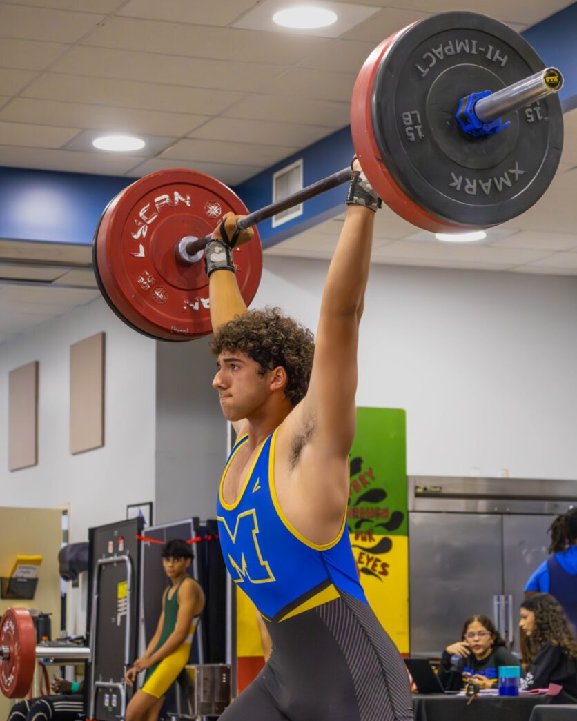 a man lifting a barbell in a gym