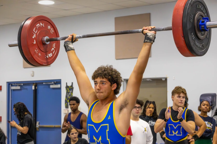 a man lifting a barbell in a gym
