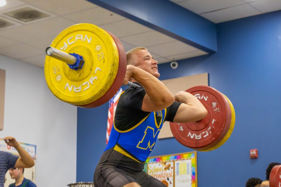 a man lifting a barbell in a gym