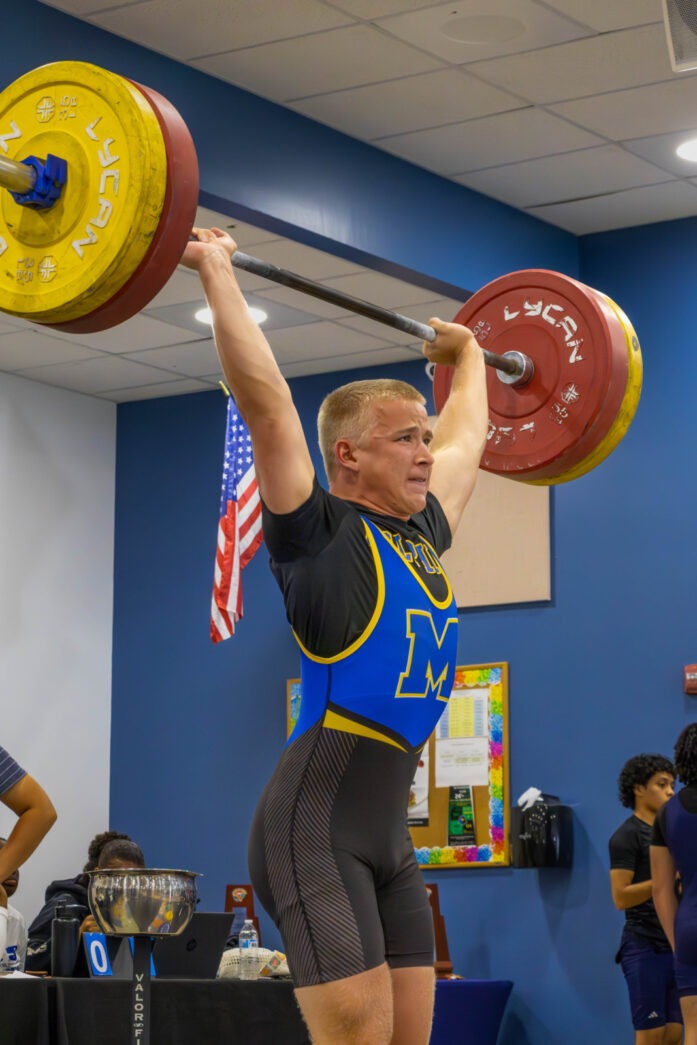 a man lifting a barbell in a gym