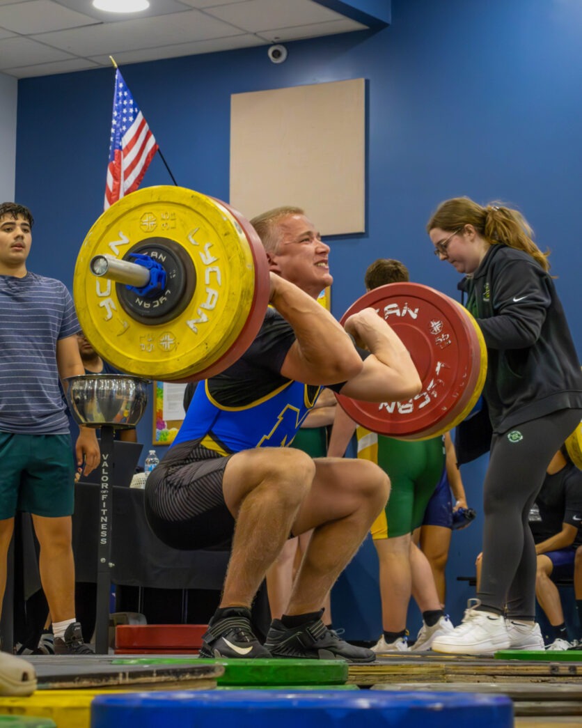a man lifting a barbell in a gym