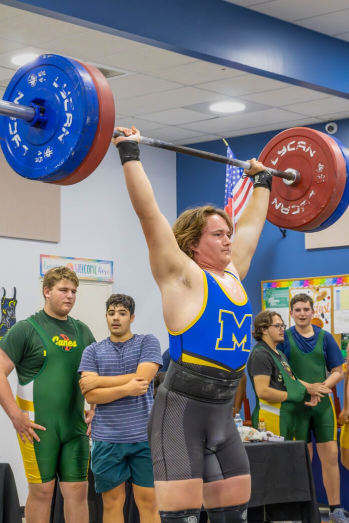 a woman lifting a barbell in a gym