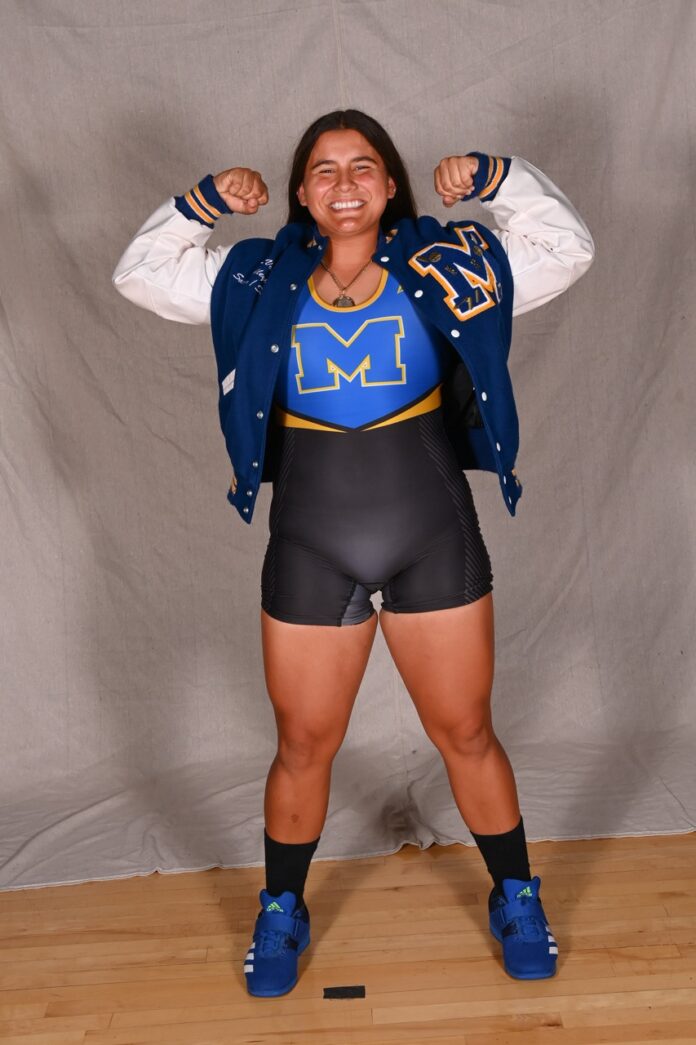 a woman in a blue jacket and black shorts