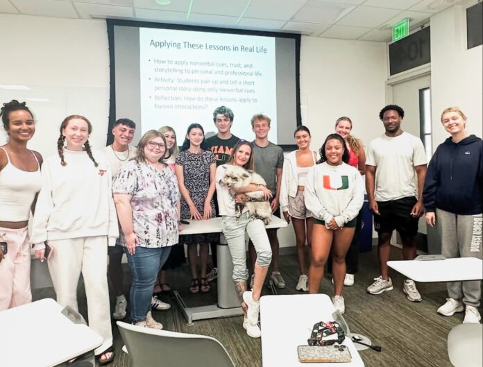 Kai with students a group of people standing in front of a projector screen